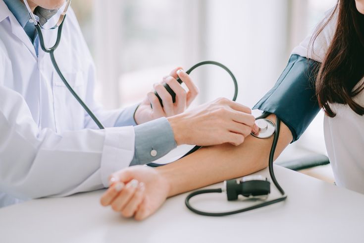 Médico tomando la presión arterial a una paciente